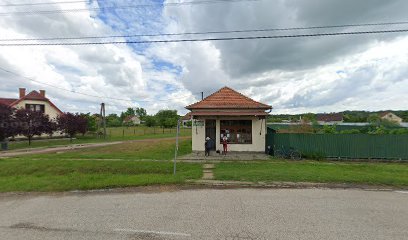 Vidéki virágbolt, kis ház, színes virágok láthatók az ablakban.